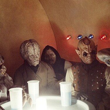 Alien patrons at a small cantina table